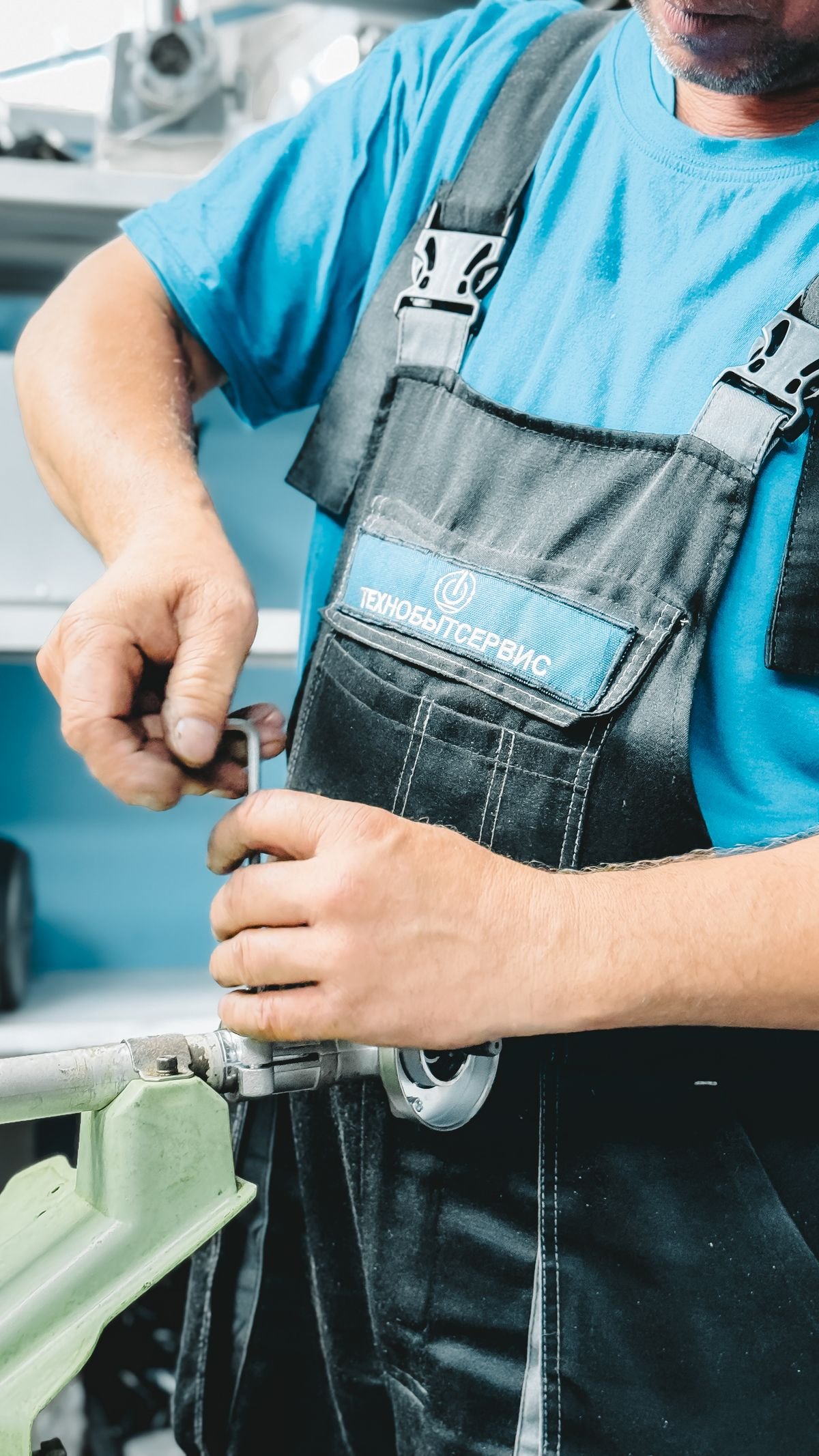 Plumber working on a pipe repair with a wrench indoors